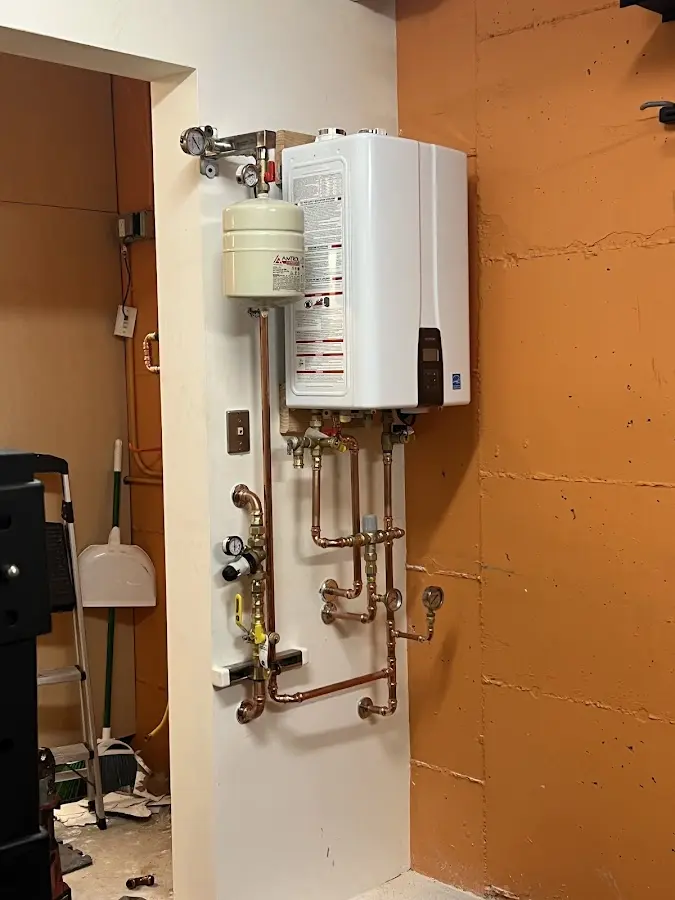 Plumbing technician inspecting water heater connections in Temescal Valley